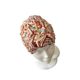 Colorful patterned headscarf on a mannequin head against a white background