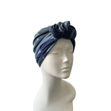 Navy and gray patterned headscarf on a mannequin head against a white background