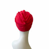 Red turban on a mannequin head against a white background