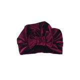 Maroon velvet headband with a bow on a white background