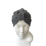 Gray turban on a mannequin head against a white background