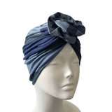 Blue and gray headscarf with a flower on a mannequin head against a white background