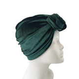 Green headscarf with a knot on a mannequin head against a white background