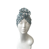 Green patterned headscarf on a mannequin head against a white background