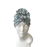Green and white patterned headscarf on a mannequin head against a white background