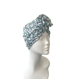 Turban with cheetah pattern on a mannequin head against a white background