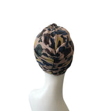 Camouflage-patterned turban on a mannequin head against a white background