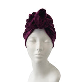 Purple headscarf with floral design on a mannequin head against a white background