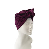 Purple turban on a mannequin head against a white background