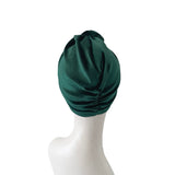 Green headscarf on a mannequin head against a white background