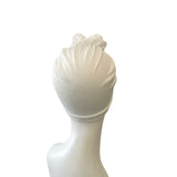 White ceramic sculpture of a face on a white background