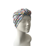 Colorful patterned headscarf on a mannequin head against a white background