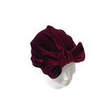 Maroon velvet turban on a mannequin head against a white background