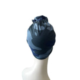 Camouflage-patterned headscarf on a mannequin head against a white background