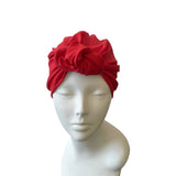 Red headscarf on a mannequin head against a white background