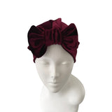 Burgundy velvet headband on a mannequin head against a white background