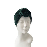 Green velvet turban on a mannequin head against a white background