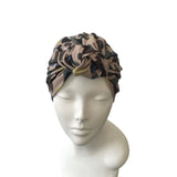Camouflage patterned headscarf on a mannequin head against a white background