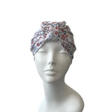 Floral patterned turban hat on a mannequin head against a white background