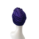 Purple headscarf on a mannequin head against a white background