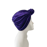 Purple turban on a mannequin head against a white background