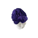 Purple turban on a mannequin head against a white background