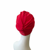 Red turban on a mannequin head against a white background