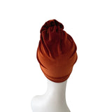 Brown turban on a white mannequin head against a white background