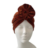 rust headscarf on a mannequin head against a white background