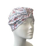 Floral patterned turban on a mannequin head against a white background