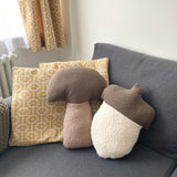 Decorative pillows on a sofa with a geometric-patterned curtain in the background