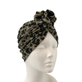 Leopard print turban on a mannequin head against a white background