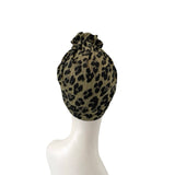 Leopard print headscarf on a mannequin head against a white background