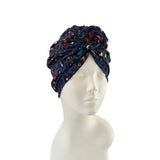 Navy blue headscarf with colorful patterns on a mannequin head against a white background