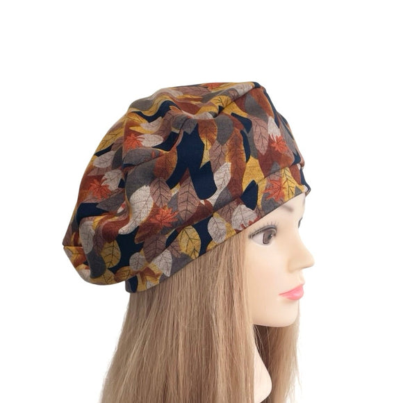 Mannequin head with long brown hair wearing a patterned beret on a white background