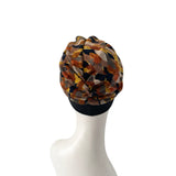 Colorful patterned headscarf on a mannequin head against a white background