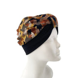 Turban with a patterned top and black band on a mannequin head against a white background