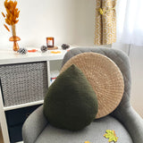 Gray armchair with decorative pillows and a small table with decor items in the background.