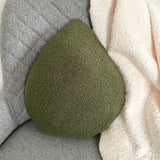 Green textured pillow on a gray and white textured surface