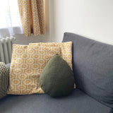 Gray sofa with patterned and solid color cushions in a room setting.