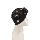 Black turban with floral detail on a mannequin head against a white background