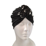 Black turban with braided design on a mannequin head against a white background