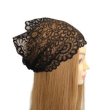Black lace headscarf on a mannequin head with blonde hair against a white background
