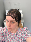 Person wearing a black lace headband in a sewing room.