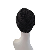 Black textured headscarf on a mannequin head against a white background