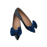 Black shoes with blue bow details on a white background