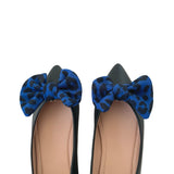 Black shoes with blue leopard print bows on a white background