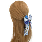 Hair scrunchie with blue and white pattern on a mannequin head with brown hair.