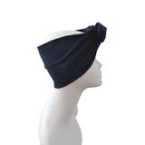 A dark navy blue fabric headwrap or turban-style headband displayed on a white mannequin head in profile against a plain white background.