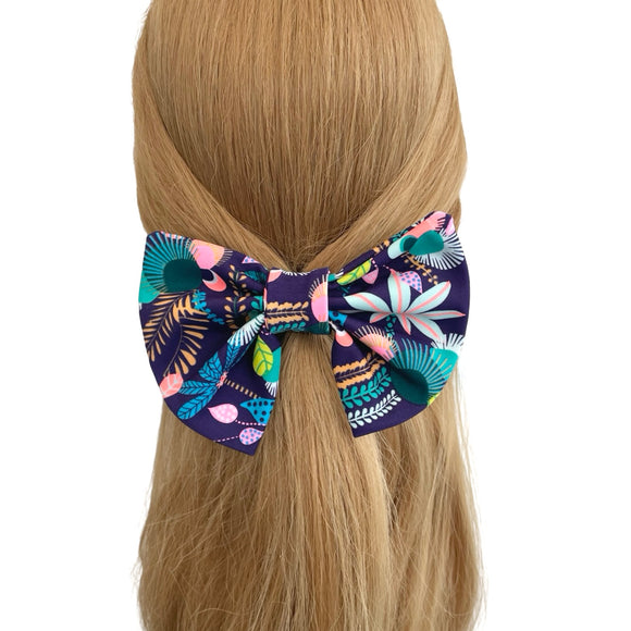 Colorful floral hair bow on a person's head with a white background